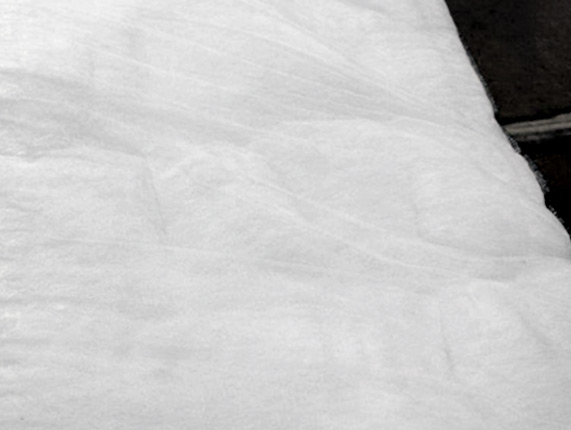 Closeup image of large sheet of white laminated fiberfill insulation called Lamilite