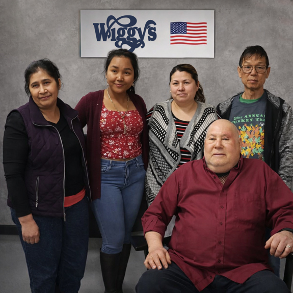 Jerry Wigutow sits next to his staff at Wiggy's, including new owner, Kok Bou