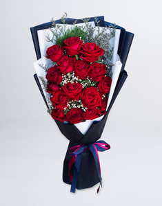 ผู้หญิงถือช่อดอกกุหลาบ จัดด้วยกุหลาบสีแดง 18 ดอก แซมดอกยิปโซและแคสเปียไว้ด้านหน้าตัวเอง