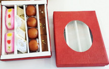Red gift box with clear window showing assorted sweets