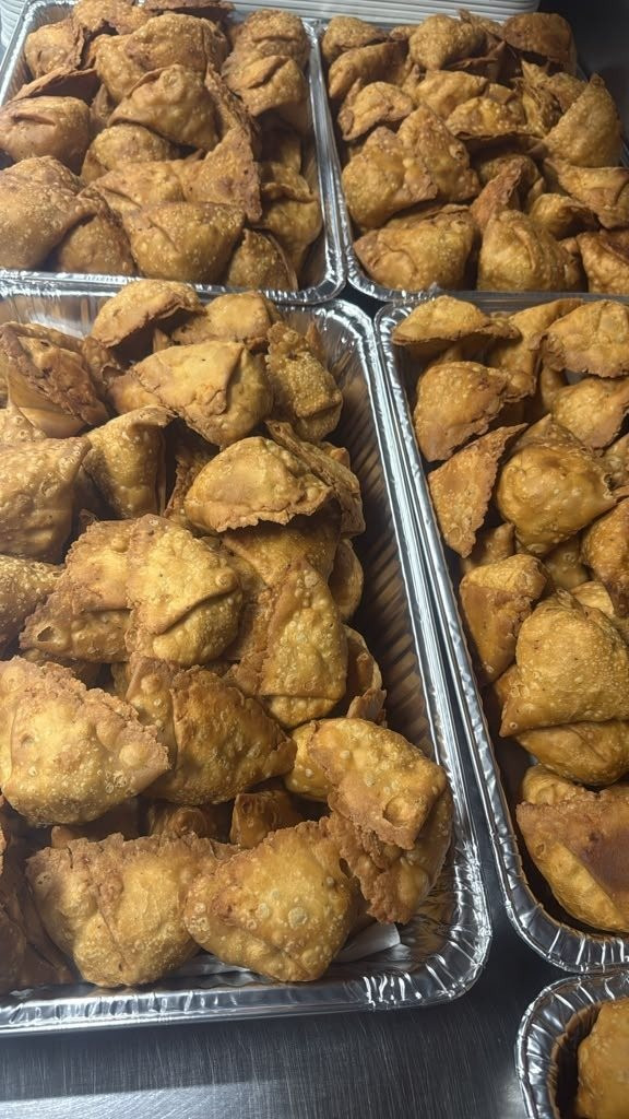 Trays of fried samosas ready for event delivery