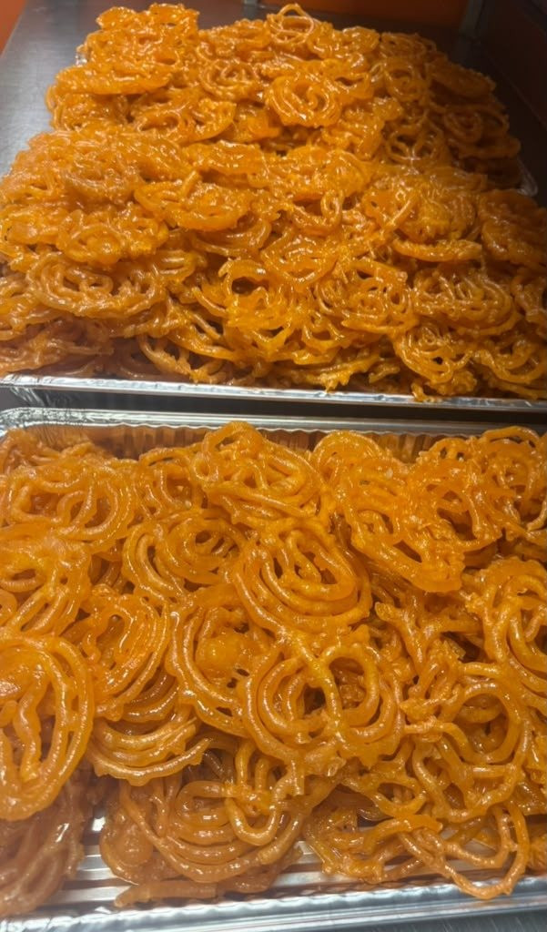 Trays of fresh jalebi spirals for event dessert tables