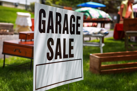 garage sale sign and furniture in the background