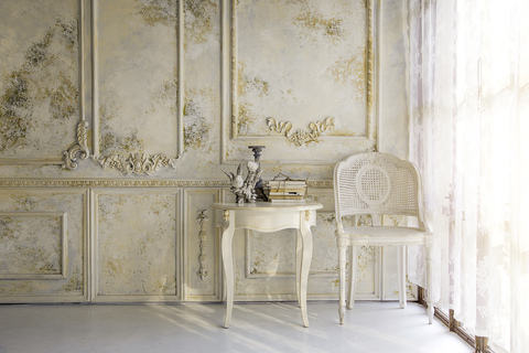 empire style chair and side table cornering a floor to ceiling window and a decorative wall