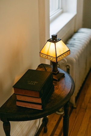 a reading nook side table with books and a lamp