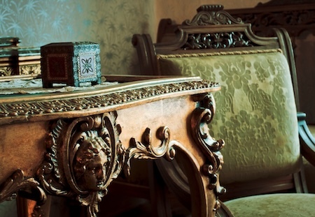 a wooden chair and table with carved accent details