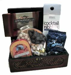 Gift basket arrangement with chocolates, sweet and salty snacks, cheese, confection caramels, dried fruit, and cookies