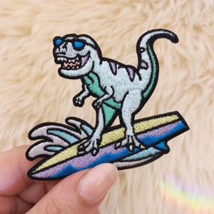 TR00476-MLT-OS - Surfing Dinosaur Patch, Small - Patches, Patch, Iron On, Iron On Patches, Patches for Jackets, Embroidered Patches, Embroidery, Embroidered, Cute Patch, Adorable Patch, Dinosaur Patch, Dino Patch, Surfing Dinosaur