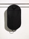 Picture of the outside of a black handled suit cover bag with accessory shirt pocket