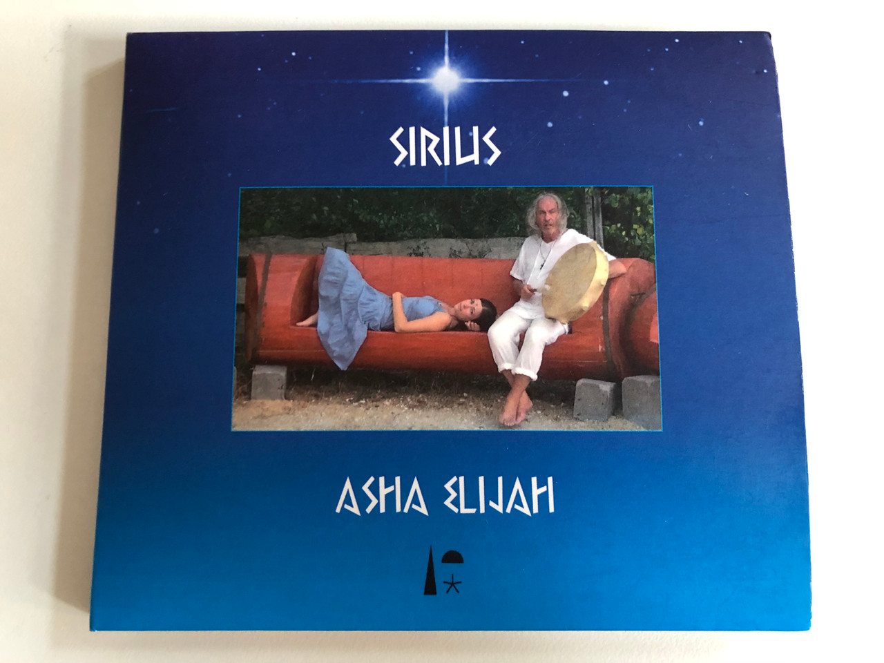 https://cdn10.bigcommerce.com/s-62bdpkt7pb/products/0/images/191286/Sirilis_-_Asha_Elijah_Singing_Stone_Music_2x_Audio_CD_SSM028_1__66289.1631596174.1280.1280.JPG?c=2&_gl=1*1iy8hv0*_ga*MjA2NTIxMjE2MC4xNTkwNTEyNTMy*_ga_WS2VZYPC6G*MTYzMTU5NDA4MS43OS4xLjE2MzE1OTU5NzcuMjA.