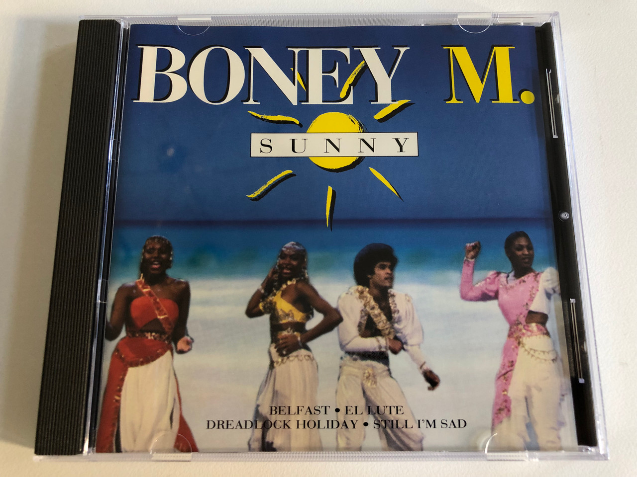 https://cdn10.bigcommerce.com/s-62bdpkt7pb/products/0/images/193364/Boney_M._Sunny_Belfast_El_Lute_Dreadlock_Holiday_Still_Im_Sad_Ariola_Express_Audio_CD_1995_Stereo_74321_24931_2_1__33799.1632931792.1280.1280.JPG?c=2&_gl=1*ag2ouw*_ga*MjA2NTIxMjE2MC4xNTkwNTEyNTMy*_ga_WS2VZYPC6G*MTYzMjkyODkwMC4xMDQuMS4xNjMyOTMxNzgwLjYw