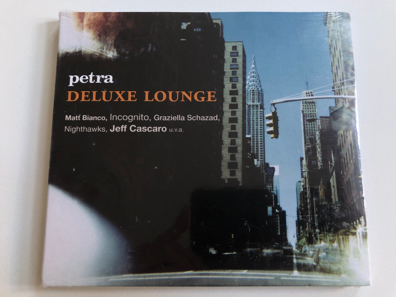https://cdn10.bigcommerce.com/s-62bdpkt7pb/products/0/images/196563/Petra_-_Deluxe_Lounge_Matt_Bianco_Incognito_Graziella_Schazad_Nighthawks_Jeff_Cascaro_u.v.a._Edel_Records_Audio_CD_2011_0206369EME_1__18396.1634821167.1280.1280.JPG?c=2&_gl=1*1nqvbvi*_ga*MjA2NTIxMjE2MC4xNTkwNTEyNTMy*_ga_WS2VZYPC6G*MTYzNDgxNzYyMy4xMzQuMS4xNjM0ODIwOTg3LjQz