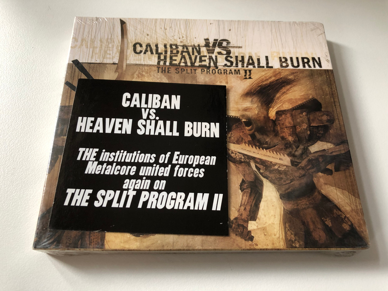 https://cdn10.bigcommerce.com/s-62bdpkt7pb/products/0/images/201148/Caliban_vs_Heaven_Shall_Burn_The_Split_Program_II_Lifeforce_Records_Audio_CD_2005_LFR_055-2_1__34625.1638820994.1280.1280.JPG?c=2&_gl=1*1hsm1v4*_ga*MjA2NTIxMjE2MC4xNTkwNTEyNTMy*_ga_WS2VZYPC6G*MTYzODgxOTE0NS4yMDMuMS4xNjM4ODIwODc4Ljc.