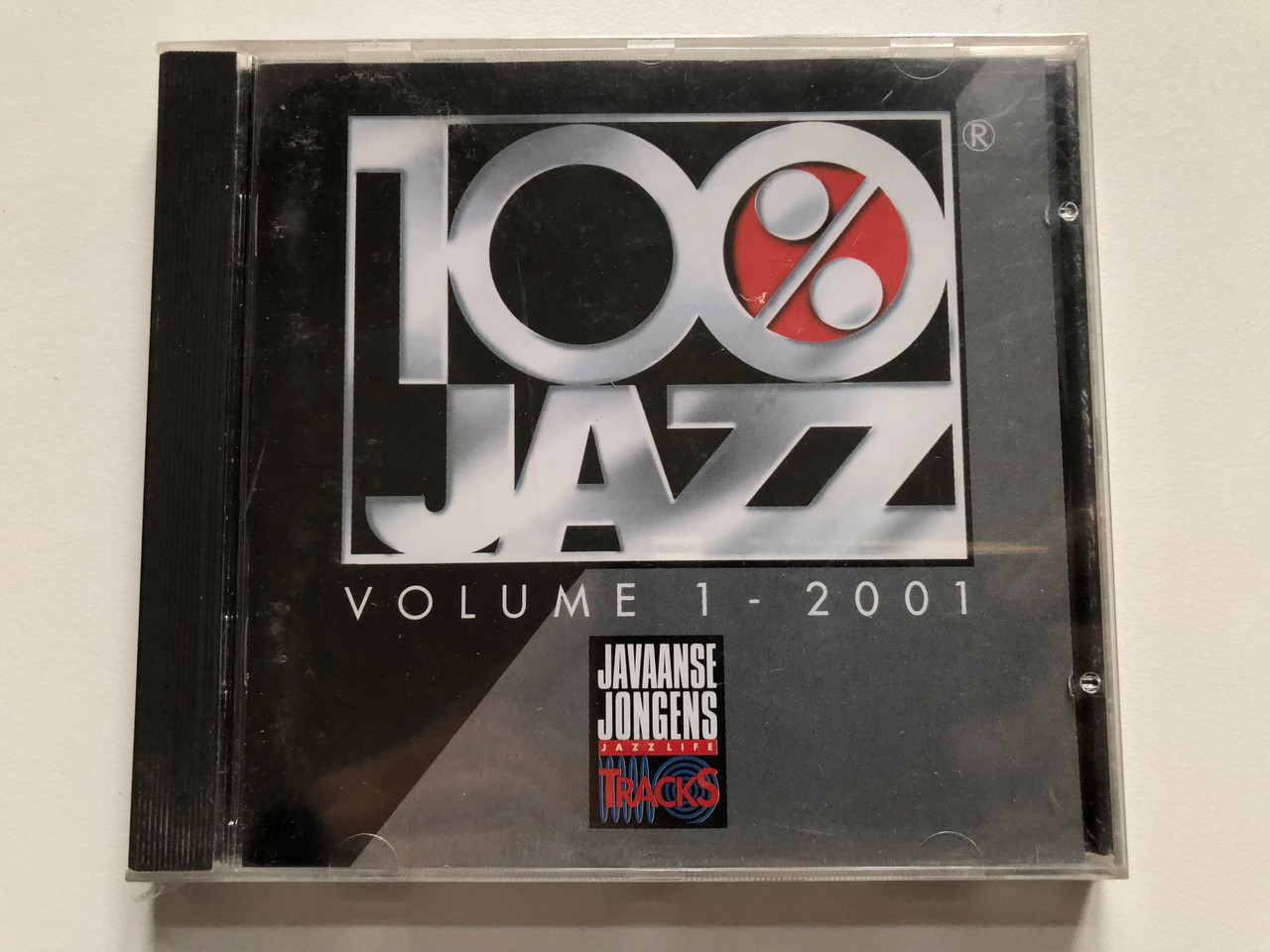 https://cdn10.bigcommerce.com/s-62bdpkt7pb/products/0/images/201846/100_Jazz_-_Volume_1_-_2001_Javaanse_Jongens_Tracks_Audio_CD_2001_JJT77004_1__35770.1639583176.1280.1280.JPG?c=2&_gl=1*1yk5o09*_ga*MjA2NTIxMjE2MC4xNTkwNTEyNTMy*_ga_WS2VZYPC6G*MTYzOTU4MDEwMS4yMTguMS4xNjM5NTgzMjEwLjYw