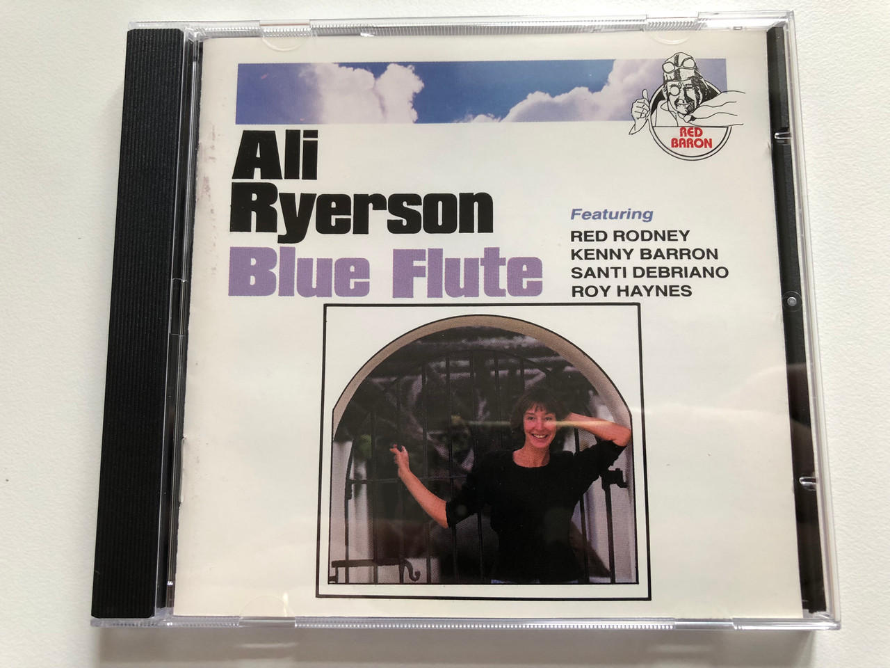 https://cdn10.bigcommerce.com/s-62bdpkt7pb/products/0/images/204901/Ali_Ryerson_Blue_Flute_Featuring_Red_Rodney_Kenny_Barron_Santi_Debriano_Roy_Haynes_Red_Baron_Audio_CD_1992_AK_48851_1__64722.1641537511.1280.1280.JPG?c=2&_gl=1*1emdps2*_ga*MjA2NTIxMjE2MC4xNTkwNTEyNTMy*_ga_WS2VZYPC6G*MTY0MTUzNDM0OS4yNTEuMS4xNjQxNTM3Mzg0LjU3