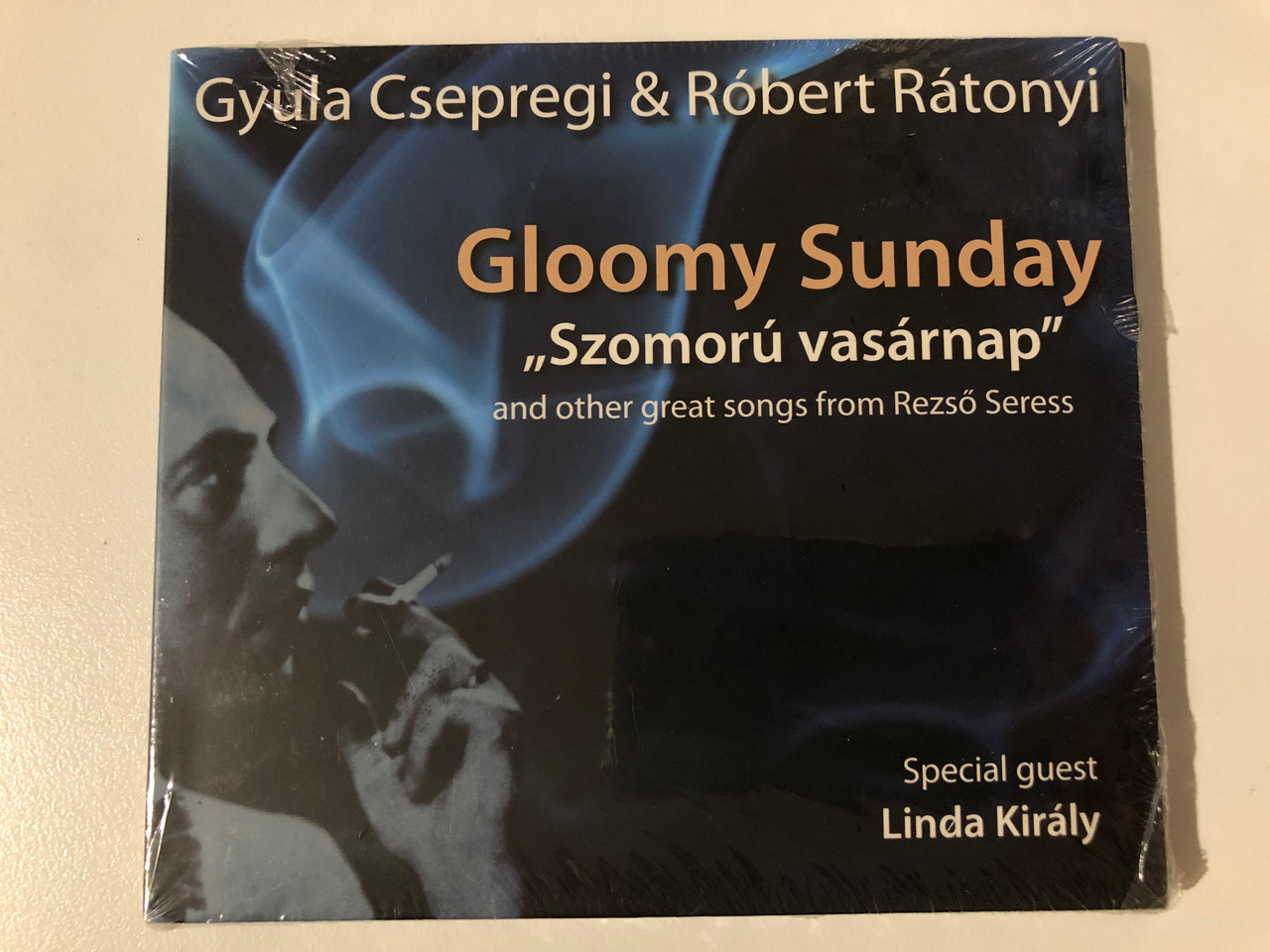 https://cdn10.bigcommerce.com/s-62bdpkt7pb/products/0/images/209343/Gyula_Csepregi_Rbert_Rtonyi_Gloomy_Sunday_Szomor_Vasrnap_and_other_great_songs_from_Rezso_Seress_Special_guest_Linda_Kiraly_EMI_Music_Hungary_Audio_CD_2009_3083052_1__75520.1643293444.1280.1280.JPG?c=2&_gl=1*1dw8lfe*_ga*MjA2NTIxMjE2MC4xNTkwNTEyNTMy*_ga_WS2VZYPC6G*MTY0MzI4OTkwNy4yNzQuMS4xNjQzMjkzMjU4LjE4