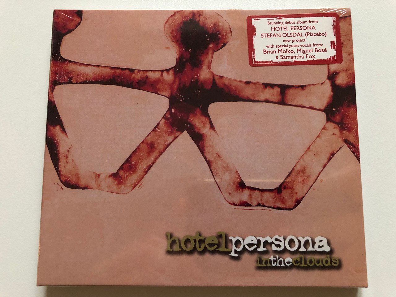 https://cdn10.bigcommerce.com/s-62bdpkt7pb/products/0/images/214080/Hotel_Persona_In_The_Clouds_Stunning_debut_album_from_Hotel_Persona_Stefan_Olsdal_Placebo_new_project_with_cpecial_guest_vocals_from_Brian_Molko_Miguel_Bose_Samantha_Fox_Edel_Record_1__34200.1645613741.1280.1280.JPG?c=2&_gl=1*9slrqv*_ga*MjA2NTIxMjE2MC4xNTkwNTEyNTMy*_ga_WS2VZYPC6G*MTY0NTYwNjA3Ni4yOTguMS4xNjQ1NjEzNzE0LjYw