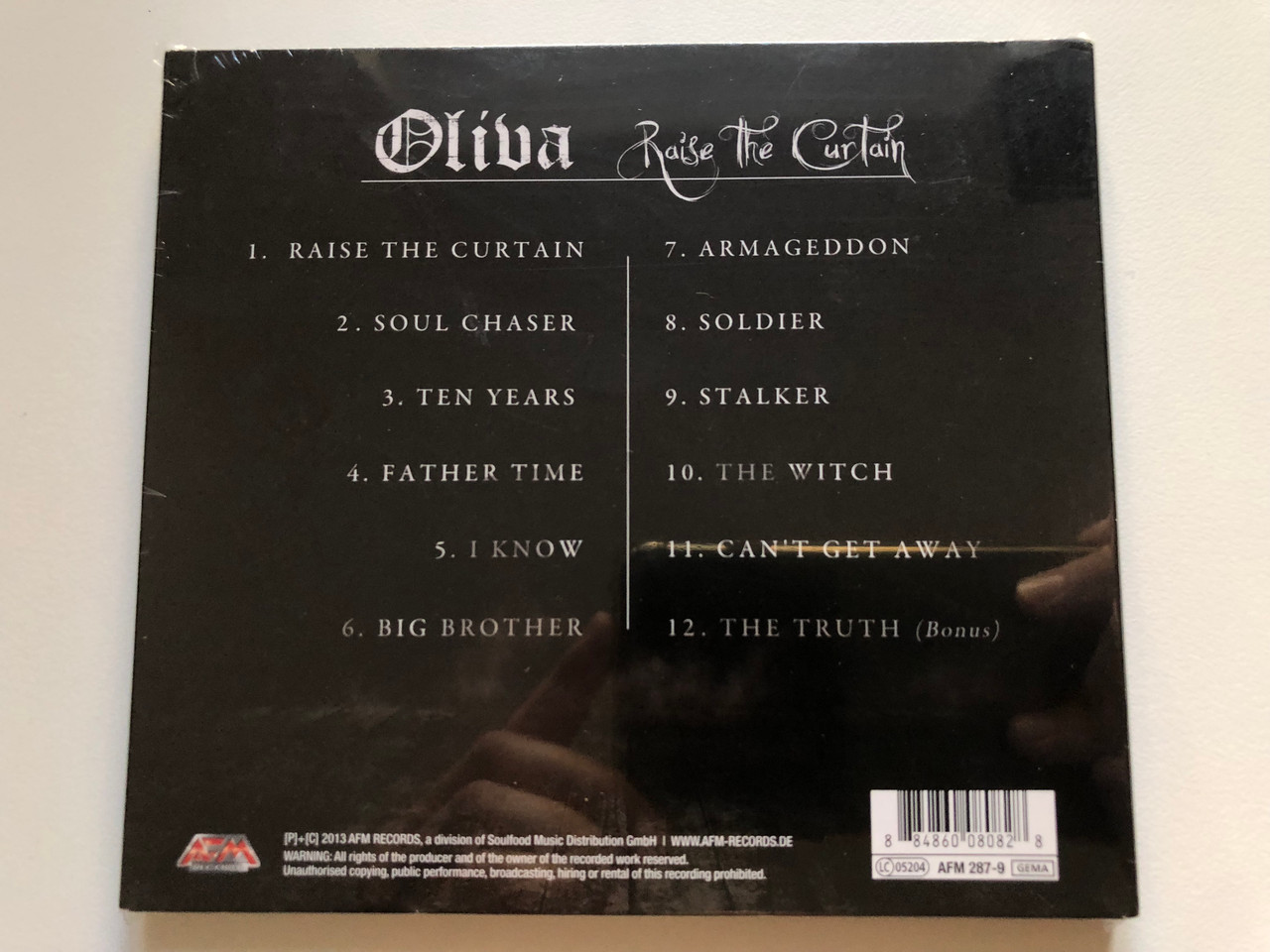 https://cdn10.bigcommerce.com/s-62bdpkt7pb/products/0/images/218443/Oliva_Raise_The_Curtain_Jon_Oliva_the_mastermind_of_Savatage_presents_his_first_Solo_Album_ever_First_Edition_Includes_One_Bonus_Track_AFM_Records_Audio_CD_2013_AFM_287-9_2__53201.1648222301.1280.1280.JPG?c=2&_gl=1*bu7ayv*_ga*MjA2NTIxMjE2MC4xNTkwNTEyNTMy*_ga_WS2VZYPC6G*MTY0ODIxMDI4Ny4zMzMuMS4xNjQ4MjIyNDA1LjYw
