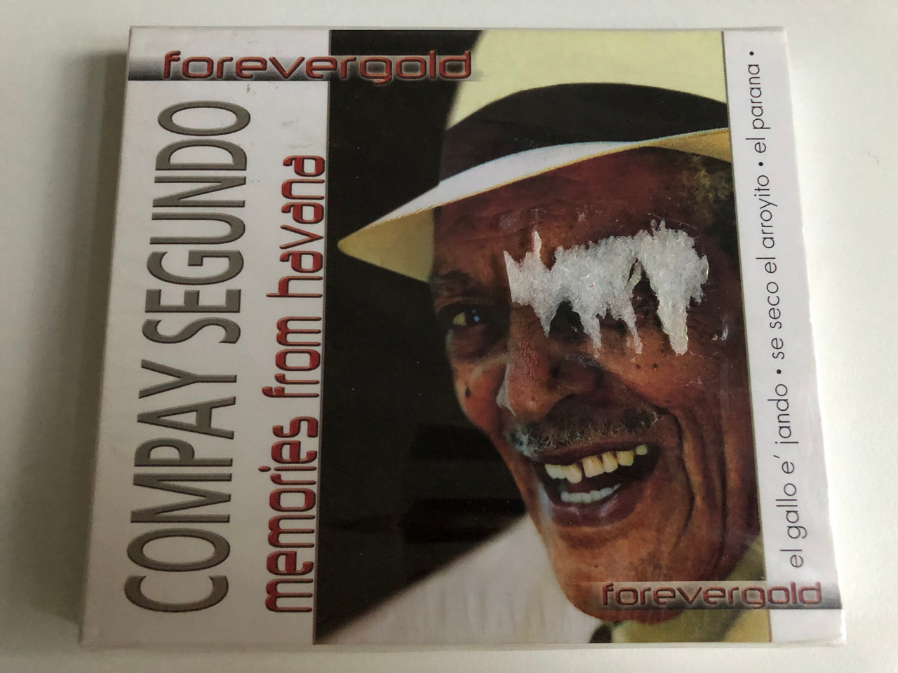 https://cdn10.bigcommerce.com/s-62bdpkt7pb/products/0/images/226605/Compay_Segundo_-_Memories_From_Havana_El_Gallo_E_Jando_Se_Seco_El_Arroyito_El_Parana_Forevergold_Luxury_Multimedia_Audio_CD_2005_2701432_1__13140.1651670545.1280.1280.JPG?c=2&_gl=1*1khj0x2*_ga*MjA2NTIxMjE2MC4xNTkwNTEyNTMy*_ga_WS2VZYPC6G*MTY1MTY2NDM1Mi4zODMuMS4xNjUxNjcwMTI1LjM.