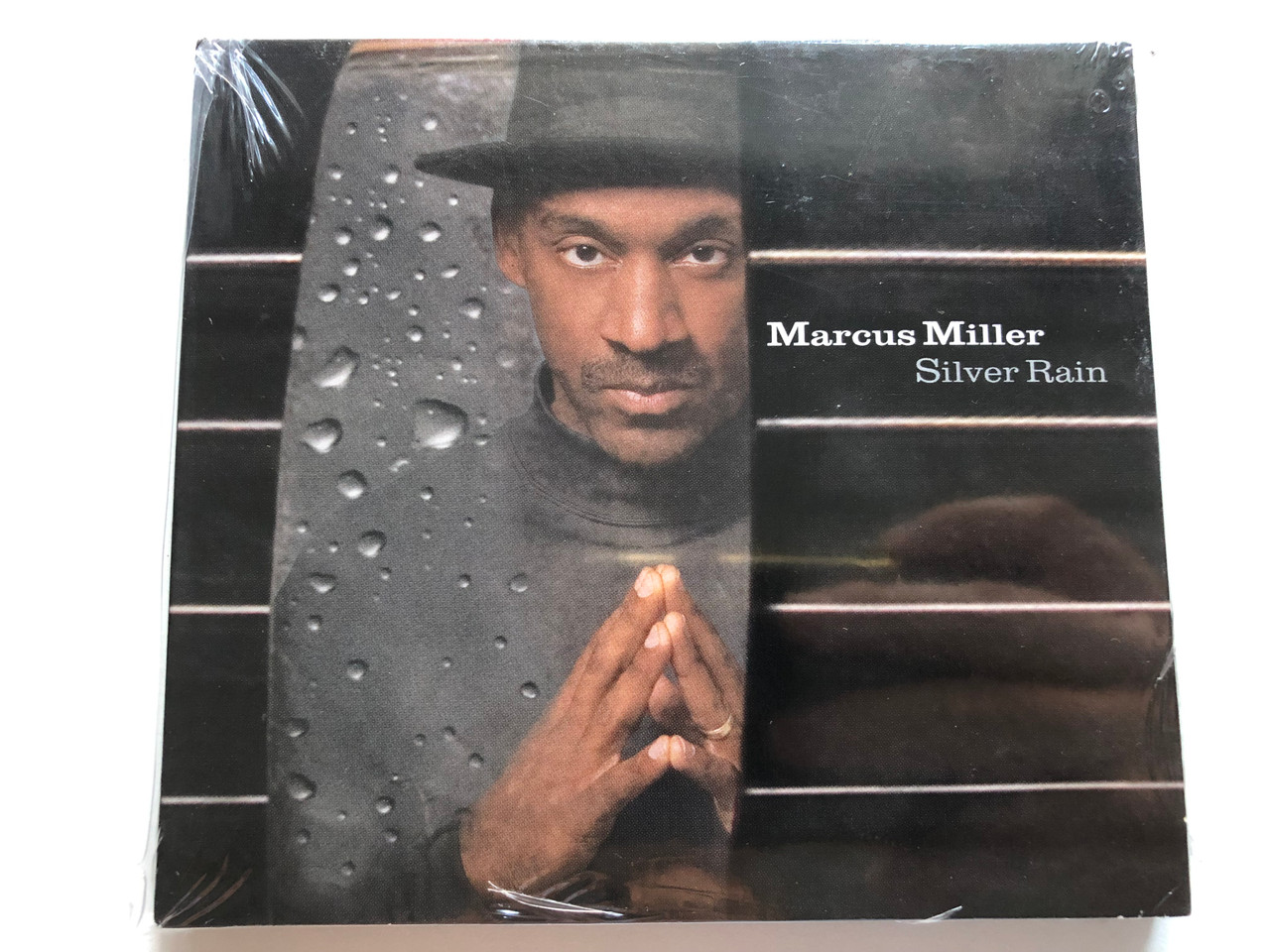 https://cdn10.bigcommerce.com/s-62bdpkt7pb/products/0/images/228239/Marcus_Miller_Silver_Rain_3_Deuces_Records_Audio_CD_2005_FDM_36673-2_1__26029.1653060564.1280.1280.JPG?c=2&_gl=1*jxfebb*_ga*MjA2NTIxMjE2MC4xNTkwNTEyNTMy*_ga_WS2VZYPC6G*MTY1MzA1NDg0MC40MDUuMS4xNjUzMDYwMjkwLjU2