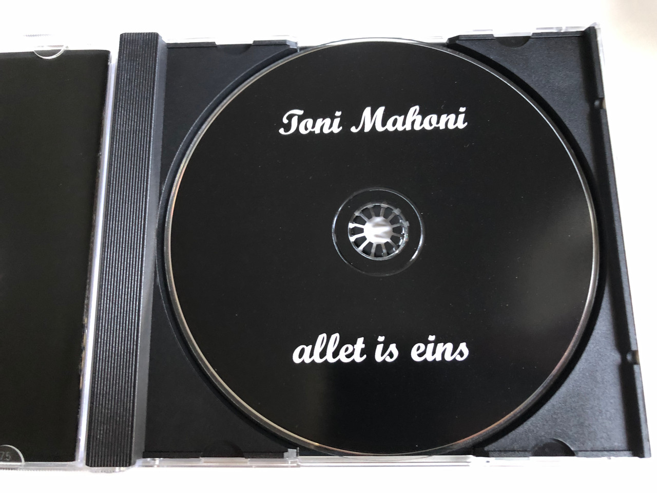 https://cdn10.bigcommerce.com/s-62bdpkt7pb/products/0/images/234549/Toni_Mahoni_Allet_Is_Eins_Audio_CD_5__04732.1655384328.1280.1280.JPG?c=2&_gl=1*aqn376*_ga*MjA2NTIxMjE2MC4xNTkwNTEyNTMy*_ga_WS2VZYPC6G*MTY1NTM4MzgxNS40MzkuMS4xNjU1Mzg0MzA0LjYw
