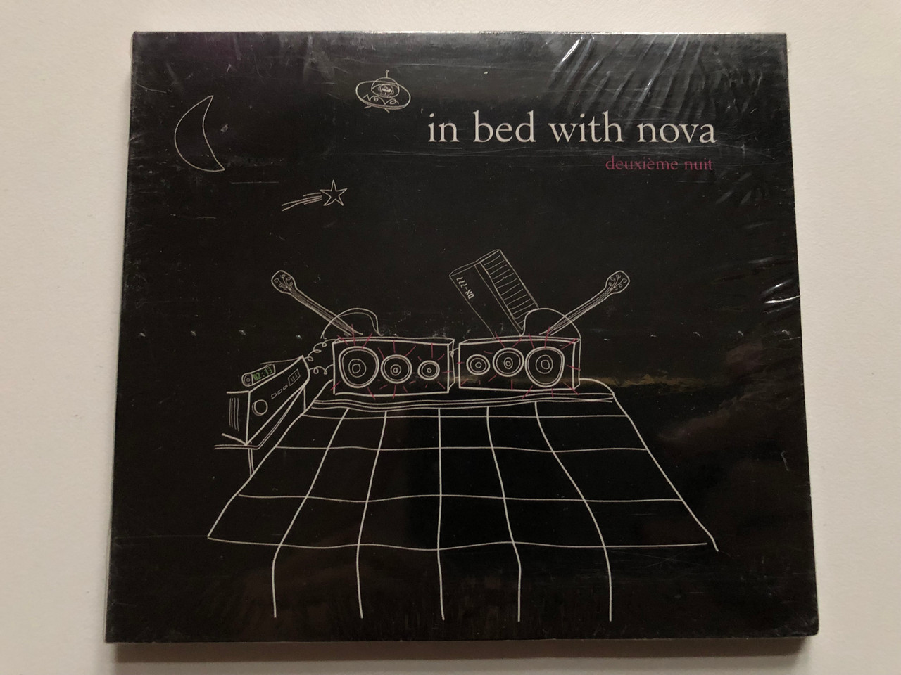 https://cdn10.bigcommerce.com/s-62bdpkt7pb/products/0/images/235064/In_Bed_With_Nova_-_Deuxime_Nuit_Nova_Records_Audio_CD_2006_3112262_1__22123.1655745568.1280.1280.JPG?c=2&_gl=1*1n2lj7o*_ga*MjA2NTIxMjE2MC4xNTkwNTEyNTMy*_ga_WS2VZYPC6G*MTY1NTc0MjI5OS40NDUuMS4xNjU1NzQ1NDcyLjI5
