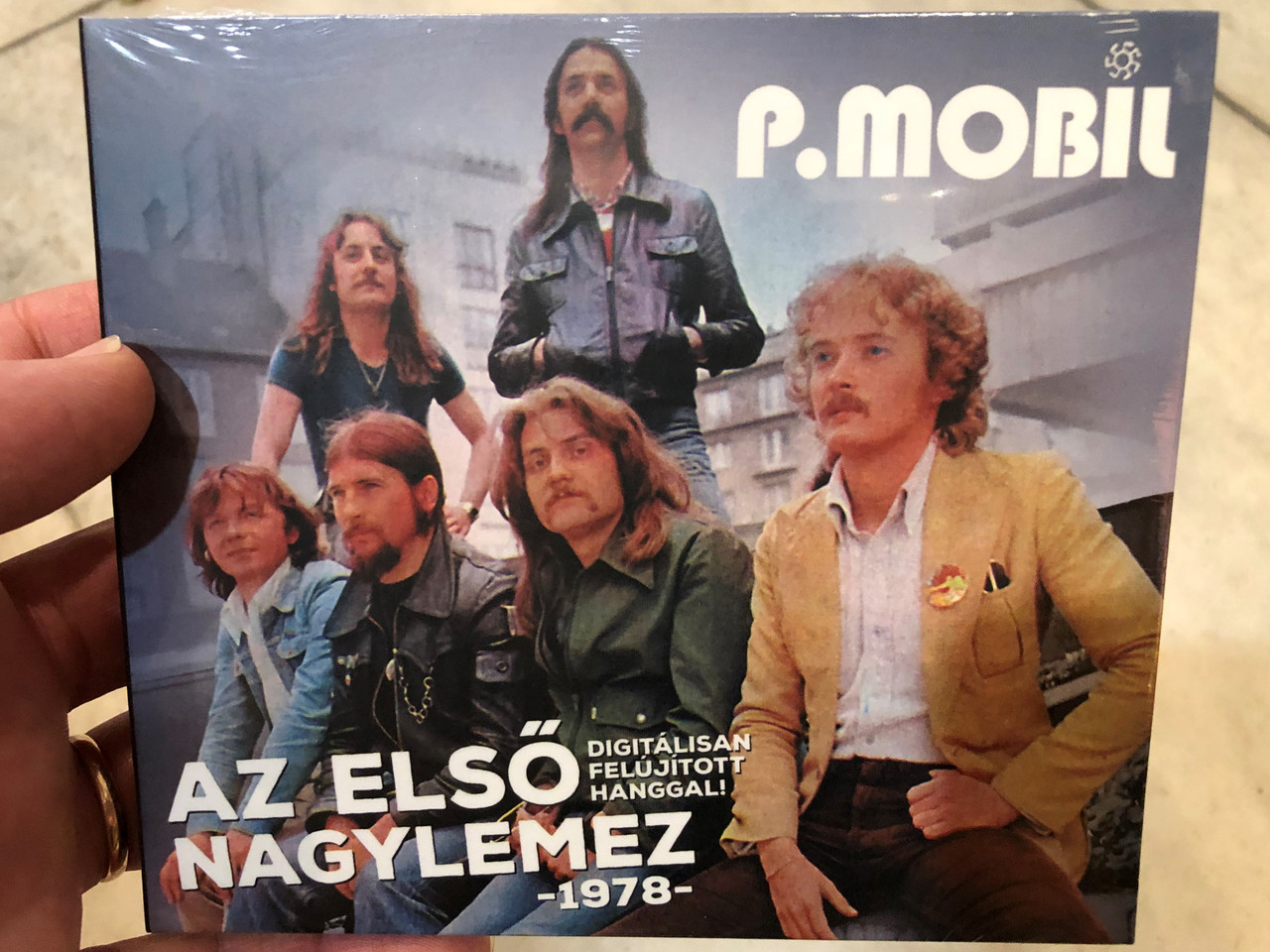 https://cdn10.bigcommerce.com/s-62bdpkt7pb/products/0/images/240128/P._Mobil_-_Az_Elso_Nagylemez_1978_-_Digitalisan_Felujitott_Hanggal_Grund_Records_Audio_CD_2022_GR206__43237.1658155641.1280.1280.JPG?c=2&_gl=1*1cswxvm*_ga*MjA2NTIxMjE2MC4xNTkwNTEyNTMy*_ga_WS2VZYPC6G*MTY1ODE1Mjc4Ni40ODUuMS4xNjU4MTU1NzU2LjYw