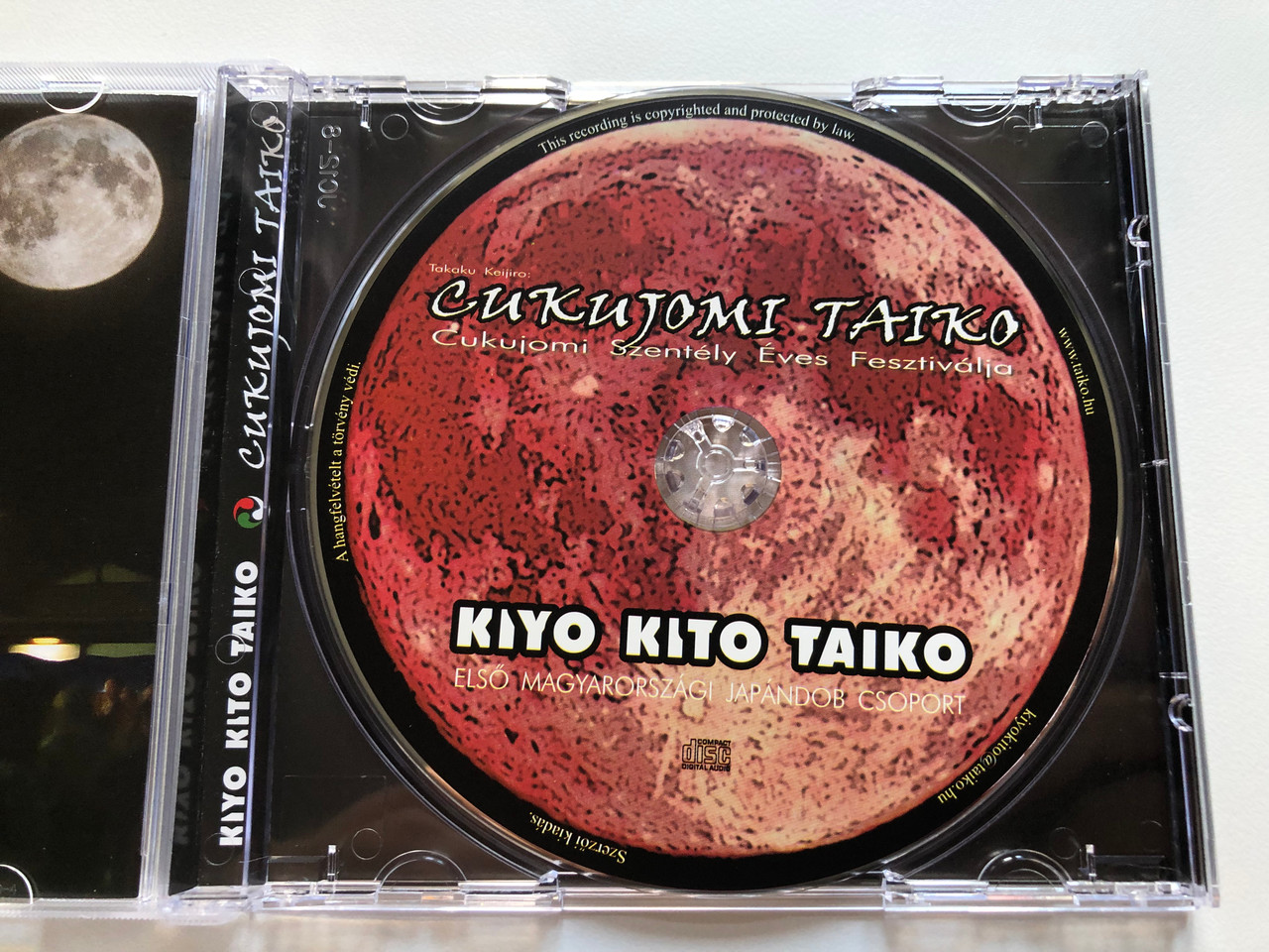 https://cdn10.bigcommerce.com/s-62bdpkt7pb/products/0/images/255737/Takaku_Keijiro_Cukujomi_Taiko_-_Cukujomi_Szentely_Eves_Fesztivalja_Kiyo-Kito_Taiko_-_Elso_Magyarorszagi_Japandob_Csoport_Audio_CD_2012_2__40880.1665131784.1280.1280.JPG?c=2&_gl=1*1ku3xir*_ga*MjA2NTIxMjE2MC4xNTkwNTEyNTMy*_ga_WS2VZYPC6G*MTY2NTEyMDY0My41ODYuMS4xNjY1MTMxODU1LjYwLjAuMA..