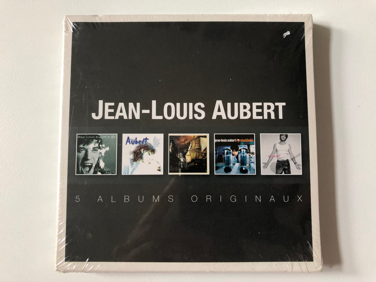 https://cdn10.bigcommerce.com/s-62bdpkt7pb/products/0/images/256966/Jean-Louis_Aubert_5_Albums_Originaux_Warner_Music_France_5x_Audio_CD_2014_Box_Set_5054196218454_1__49457.1666797233.1280.1280.JPG?c=2&_gl=1*1j1aai7*_ga*MjA2NTIxMjE2MC4xNTkwNTEyNTMy*_ga_WS2VZYPC6G*MTY2Njc5NDA3MC42MDQuMS4xNjY2Nzk3MTI1LjMzLjAuMA..