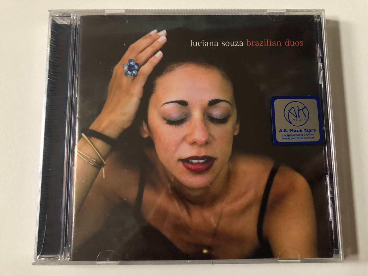 https://cdn10.bigcommerce.com/s-62bdpkt7pb/products/0/images/257405/Luciana_Souza_Brazilian_Duos_Sunnyside_Audio_CD_2002_SSC_1100_1__83849.1667292773.1280.1280.JPG?c=2&_gl=1*tqrw1y*_ga*MjA2NTIxMjE2MC4xNTkwNTEyNTMy*_ga_WS2VZYPC6G*MTY2NzI4NTYzMC42MTEuMS4xNjY3MjkyNjU2LjM4LjAuMA..