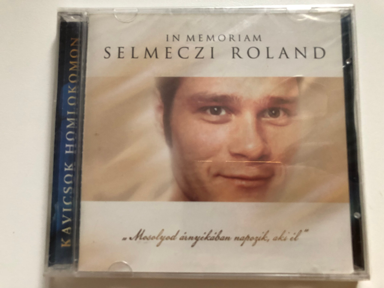 https://cdn10.bigcommerce.com/s-62bdpkt7pb/products/0/images/261897/In_memoriam_Selmeczi_Roland_Mosolyod_arnyekaban_napozik_aki_el_Audio_CD_2008_1__33007.1671743250.1280.1280.JPG?c=2&_gl=1*itxnx8*_ga*MjA2NTIxMjE2MC4xNTkwNTEyNTMy*_ga_WS2VZYPC6G*MTY3MTczNzIwMi42ODQuMS4xNjcxNzQzMDE4LjM0LjAuMA..
