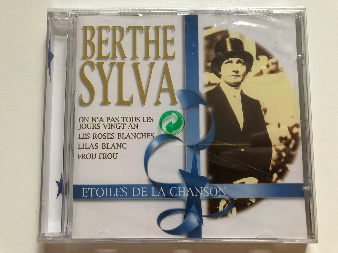 https://cdn10.bigcommerce.com/s-62bdpkt7pb/products/0/images/264678/Berthe_Sylva_Etoiles_De_La_Chanson_On_Na_Pas_Tous_Les_Jours_Vingt_An_Les_Roses_Blanches_Lilas_Blanc_Frou_Frou_Disky_Audio_CD_1999_FSI_855872_1__33078.1674538686.1280.1280.JPG?c=2&_gl=1*gkakw*_ga*MjA2NTIxMjE2MC4xNTkwNTEyNTMy*_ga_WS2VZYPC6G*MTY3NDUzNDI1MC43MjYuMS4xNjc0NTM4MjIzLjM3LjAuMA..