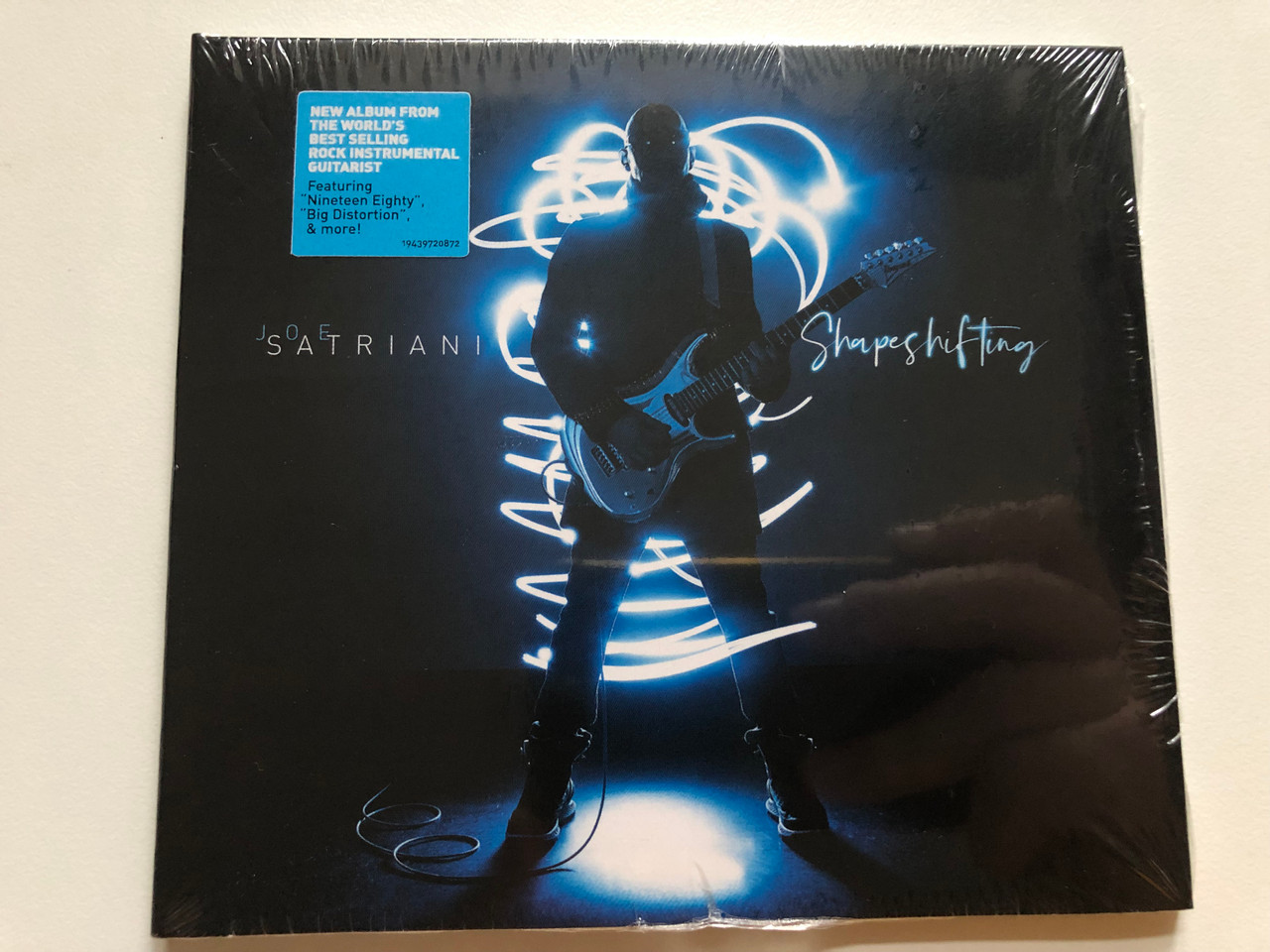 https://cdn10.bigcommerce.com/s-62bdpkt7pb/products/0/images/264806/Joe_Satriani_Shapeshifting_New_Album_From_The_Worlds_Best_Selling_Rock_Instrumental_Guitarist_Featuring_Nineteen_Eighty_Big_Distortion_more_Legacy_Audio_CD_2020_19439720872_1__73809.1674640016.1280.1280.JPG?c=2&_gl=1*1d0p2tq*_ga*MjA2NTIxMjE2MC4xNTkwNTEyNTMy*_ga_WS2VZYPC6G*MTY3NDYzMzI2OS43MzAuMS4xNjc0NjM5NzY5LjQyLjAuMA..