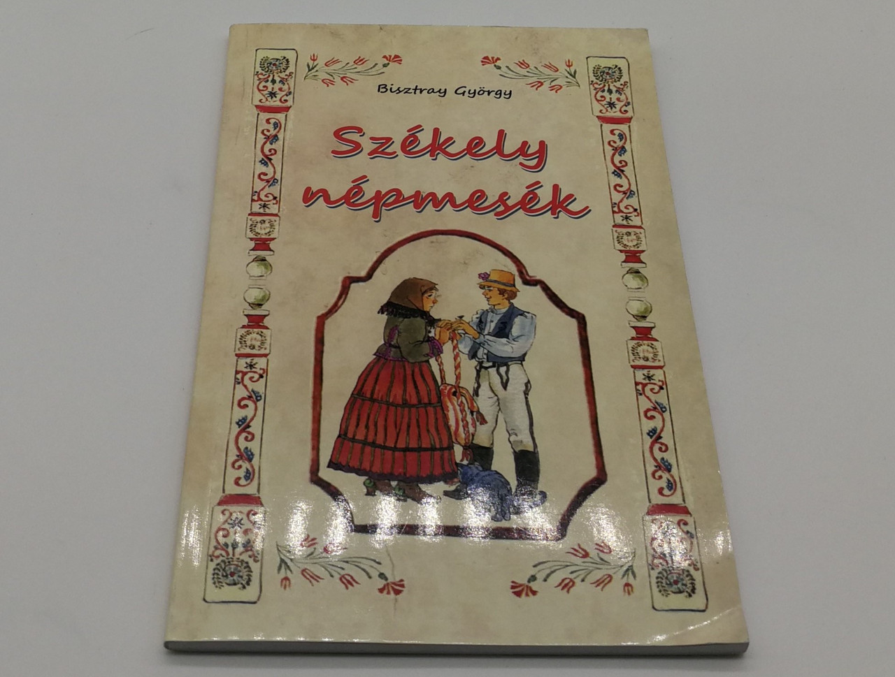 https://cdn10.bigcommerce.com/s-62bdpkt7pb/products/0/images/268348/Szkely_npmesk_By_Bisztray_Gyorgy_Nemzeti_Orokseg_Kiado_Mid_Size_Paperback_1__83481.1677693854.1280.1280.jpg?c=2&_gl=1*9t4chz*_ga*MjA2NTIxMjE2MC4xNTkwNTEyNTMy*_ga_WS2VZYPC6G*MTY3NzY4MTgzOC43ODMuMS4xNjc3NjkzODkxLjYwLjAuMA..