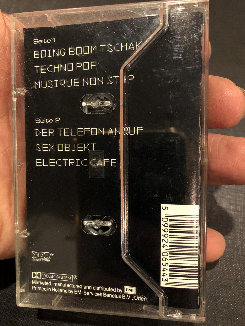https://cdn10.bigcommerce.com/s-62bdpkt7pb/products/0/images/269057/Kraftwerk_Electric_Cafe_Deutsche_Version_EMI_Audio_Cassette_264_240654_4_2__62266.1678164772.1280.1280.JPG?c=2&_gl=1*zajlta*_ga*MjA2NTIxMjE2MC4xNTkwNTEyNTMy*_ga_WS2VZYPC6G*MTY3ODE2NDQ5OC43OTMuMC4xNjc4MTY0NDk4LjYwLjAuMA..