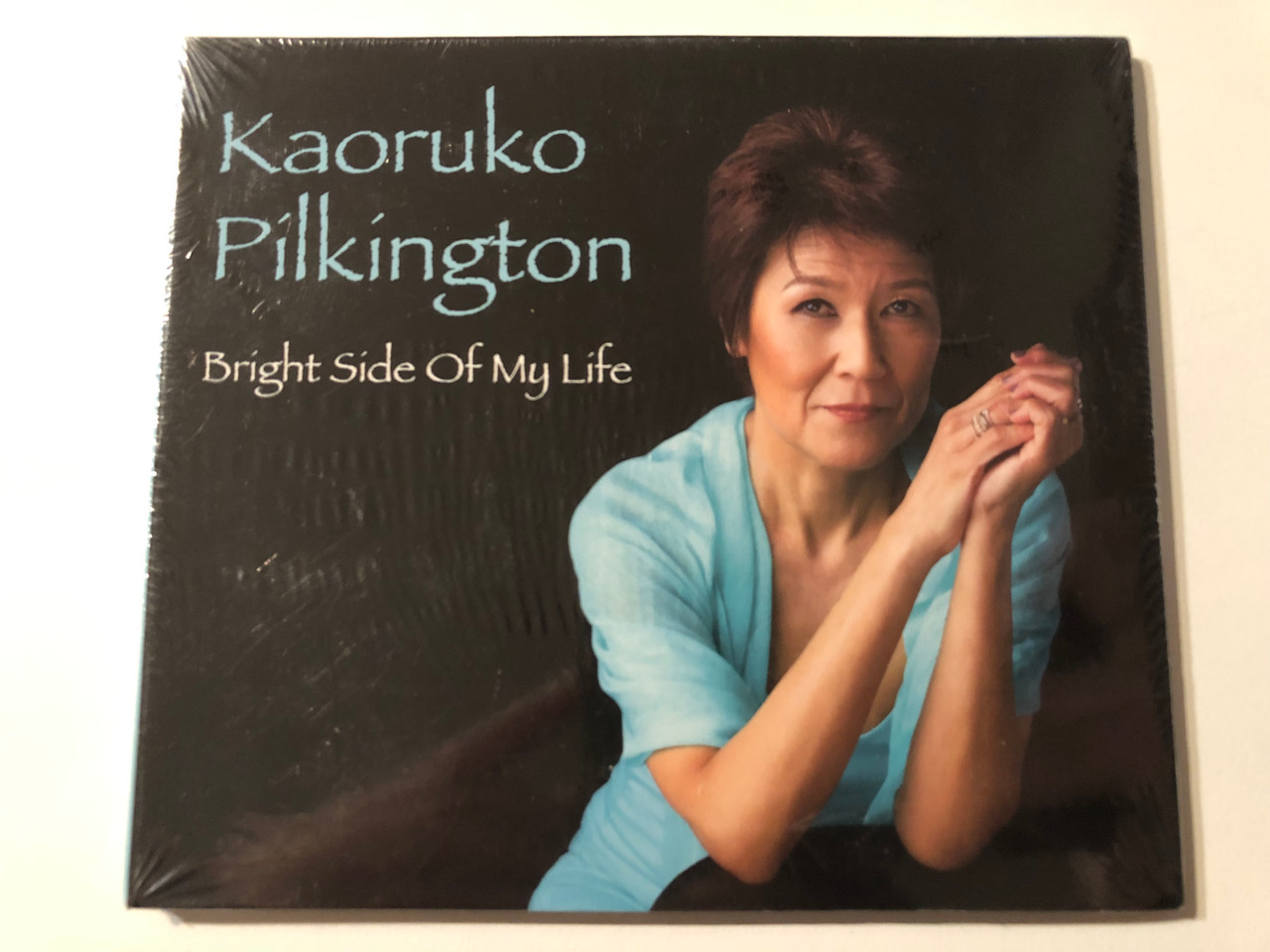 https://cdn10.bigcommerce.com/s-62bdpkt7pb/products/0/images/269628/Kaoruko_Pilkington_-_Bright_Side_of_My_Life_Audio_CD_2014_1__14287.1678956363.1280.1280.JPG?c=2&_gl=1*18nm808*_ga*MjA2NTIxMjE2MC4xNTkwNTEyNTMy*_ga_WS2VZYPC6G*MTY3ODk1NTEyNy44MDcuMS4xNjc4OTU2MTU1LjExLjAuMA..