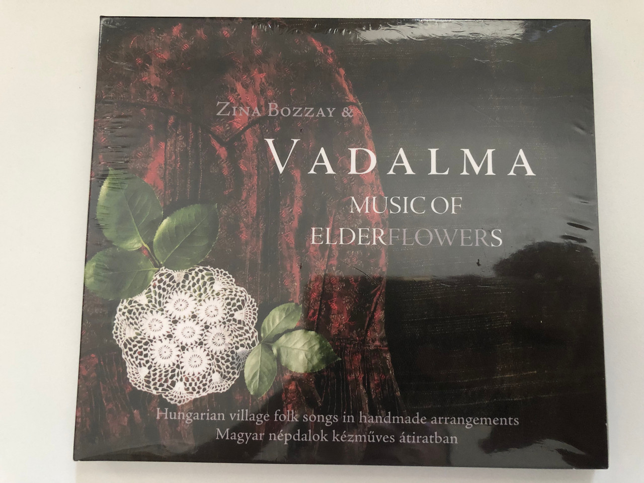 https://cdn10.bigcommerce.com/s-62bdpkt7pb/products/0/images/269761/Zina_Bozzay_Vadalma_-_Music_of_Elderflowers_Hungarian_village_folk_songs_in_handmade_arrangements_Elder_Records_Audio_CD_2018_ELD-013_1__72666.1679074201.1280.1280.JPG?c=2&_gl=1*1vobo6i*_ga*MjA2NTIxMjE2MC4xNTkwNTEyNTMy*_ga_WS2VZYPC6G*MTY3OTA2NTc5Mi44MTEuMS4xNjc5MDczNjQwLjQ0LjAuMA..