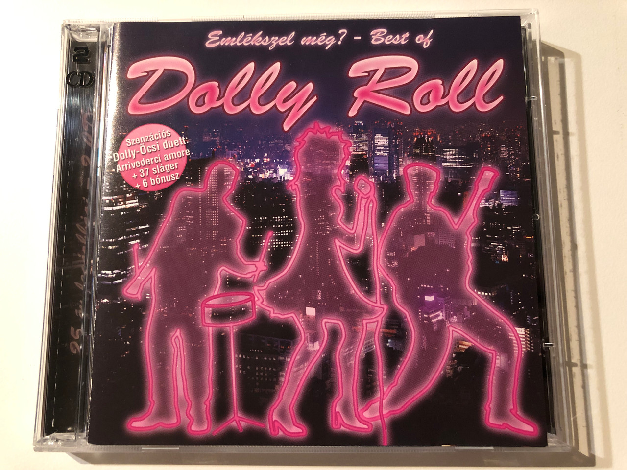 https://cdn10.bigcommerce.com/s-62bdpkt7pb/products/0/images/270249/Emlkszel_Mg_-_Best_Of_Dolly_Roll_Szenzacios_Dolly-Ocsi_duett_Arrivederci_amore_37_slager_bonusz_Hargent_Media_2x_Audio_CD_2009_HG754_1__48989.1679480255.1280.1280.JPG?c=2&_gl=1*1wpbjbg*_ga*MjA2NTIxMjE2MC4xNTkwNTEyNTMy*_ga_WS2VZYPC6G*MTY3OTQ3NzI2My44MTYuMS4xNjc5NDgwNzI2LjYwLjAuMA..