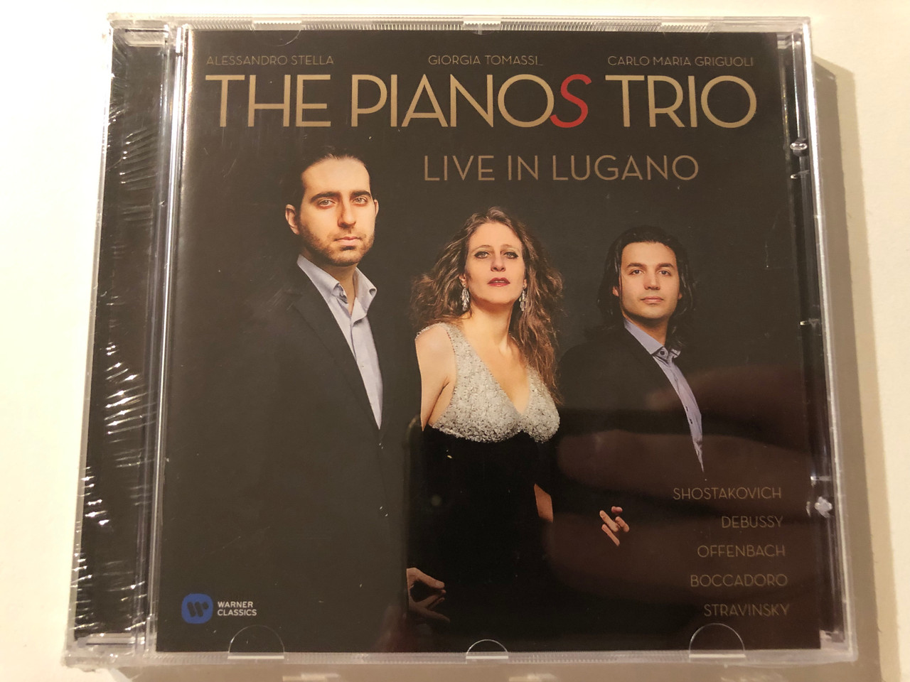 https://cdn10.bigcommerce.com/s-62bdpkt7pb/products/0/images/275965/The_Pianos_Trio_Alessandro_Stella_Giorgia_Tomassi_Carlo_Maria_Griguoli_-_Live_In_Lugano_-_Shostakovich_Debussy_Offenbach_Boccadoro_Stravinsky_Warner_Classics_Audio_CD_2014_08256462880_1__07954.1685984163.1280.1280.JPG?c=2&_gl=1*7ef75f*_ga*MjA2NTIxMjE2MC4xNTkwNTEyNTMy*_ga_WS2VZYPC6G*MTY4NTk4MTQzMi45MjguMS4xNjg1OTgzODI2LjU3LjAuMA..
