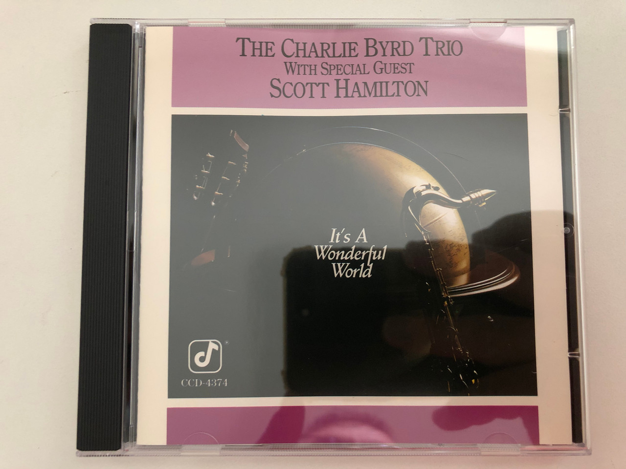 https://cdn10.bigcommerce.com/s-62bdpkt7pb/products/0/images/276244/The_Charlie_Byrd_Trio_With_Special_Guest_Scott_Hamilton_Its_A_Wonderful_World_Concord_Jazz_Audio_CD_1989_CCD-4374_1__40206.1686320861.1280.1280.JPG?c=2&_gl=1*oww6vf*_ga*MjA2NTIxMjE2MC4xNTkwNTEyNTMy*_ga_WS2VZYPC6G*MTY4NjMyMDY5Mi45MzUuMC4xNjg2MzIwNjkyLjYwLjAuMA..