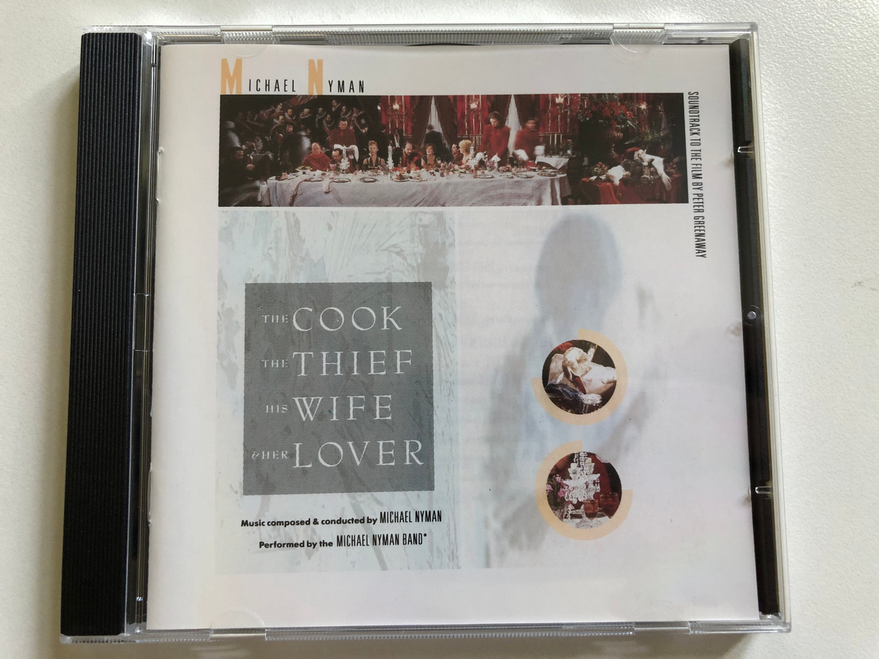 https://cdn10.bigcommerce.com/s-62bdpkt7pb/products/0/images/298433/Michael_Nyman_The_Cook_The_Thief_His_Wife_And_Her_Lover_-_Music_Composed_Conducted_By_Michael_Nyman_Performed_By_The_Michael_Nyman_Band_Soundtrack_To_The_Film_By_Peter_Greenaway_Virgin_1__69022.1693820951.1280.1280.JPG?c=2&_gl=1*8ql2tu*_ga*MjA2NTIxMjE2MC4xNTkwNTEyNTMy*_ga_WS2VZYPC6G*MTY5MzgxNDQzNy4xMDU3LjEuMTY5MzgyMDUyMy41MC4wLjA.