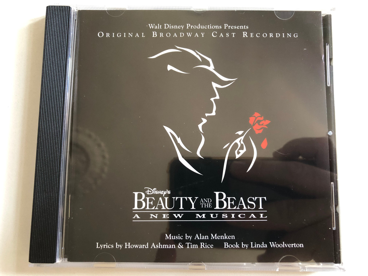 https://cdn10.bigcommerce.com/s-62bdpkt7pb/products/0/images/298529/Beauty_And_The_Beast_-_A_New_Musical_Original_Broadway_Cast_Recording_-_Music_By_Alan_Menken_Lyrics_by_Howard_Ashman_Tim_Rice_Book_By_Linda_Woolverton_Walt_Disney_Records_Audio_CD_2007_1__99925.1693890147.1280.1280.JPG?c=2&_gl=1*14qyxap*_ga*MjA2NTIxMjE2MC4xNTkwNTEyNTMy*_ga_WS2VZYPC6G*MTY5Mzg4OTk2My4xMDU4LjAuMTY5Mzg4OTk2My42MC4wLjA.