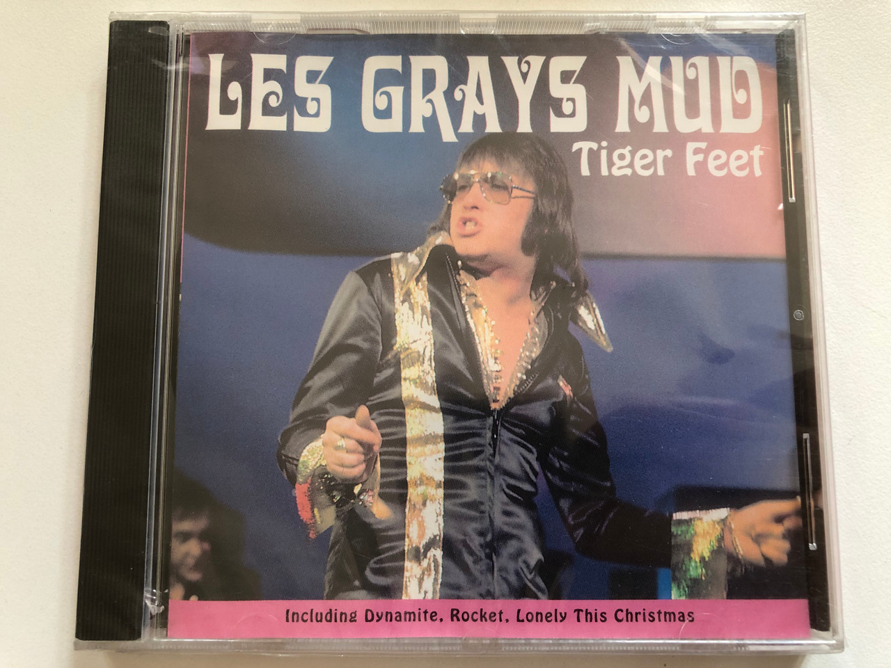 https://cdn10.bigcommerce.com/s-62bdpkt7pb/products/0/images/300308/Les_Grays_Mud_-_Tiger_Feet_Including_Dynamite_Rocket_Lonely_This_Christmas_FMCG_Audio_CD_1997_FMC026_1__70087.1694449560.1280.1280.JPG?c=2&_gl=1*j3r7qb*_ga*MjA2NTIxMjE2MC4xNTkwNTEyNTMy*_ga_WS2VZYPC6G*MTY5NDQ0ODU0Ny4xMDY1LjEuMTY5NDQ0OTU1Ny42MC4wLjA.