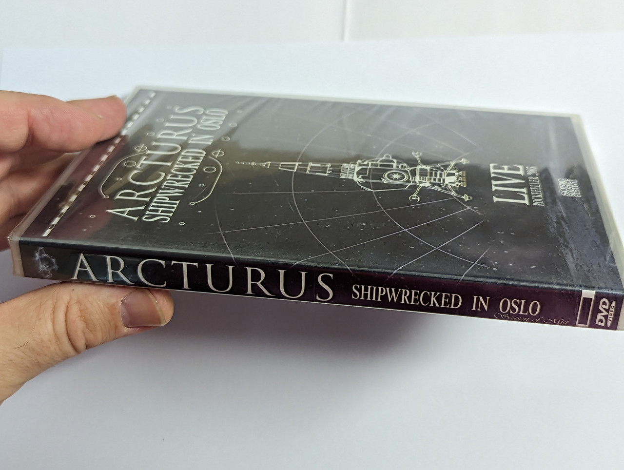 https://cdn10.bigcommerce.com/s-62bdpkt7pb/products/0/images/302470/Arcturus_Shipwrecked_In_Oslo_-_Live_Rockefeller_2005_Season_Of_Mist_DVD_Video_CD_SOM_128_3__47782.1696412663.1280.1280.jpg?c=2&_gl=1*19236hl*_ga*MjA2NTIxMjE2MC4xNTkwNTEyNTMy*_ga_WS2VZYPC6G*MTY5NjQwNzEwMS4xMDg1LjEuMTY5NjQxMjY1MS42MC4wLjA.