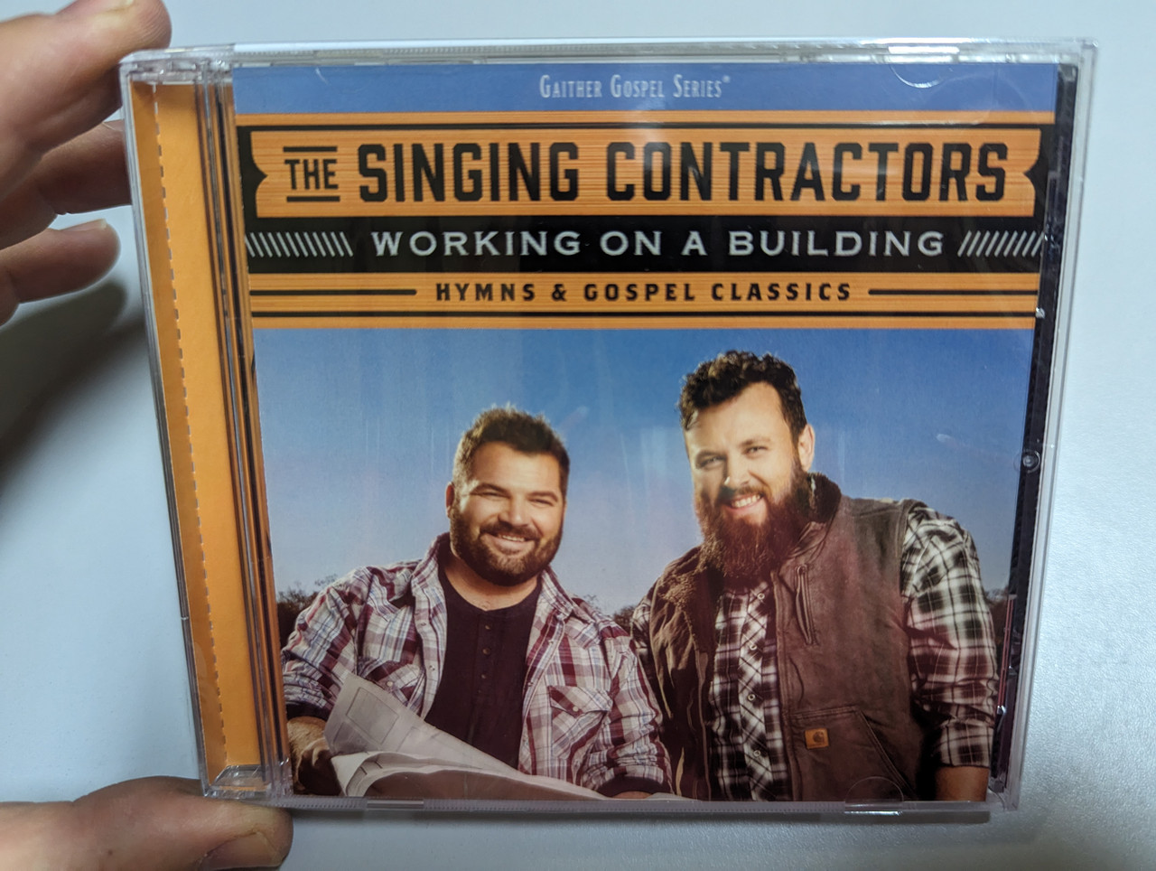 https://cdn10.bigcommerce.com/s-62bdpkt7pb/products/0/images/303062/The_Singing_Contractors_Working_On_A_Building_Hymns_Gospel_Classics_Gaither_Music_Group_Audio_CD_2019_SHD9404_1__18811.1696944935.1280.1280.jpg?c=2&_gl=1*g7vvoa*_ga*MjA2NTIxMjE2MC4xNTkwNTEyNTMy*_ga_WS2VZYPC6G*MTY5Njk0MjMxNy4xMDk1LjEuMTY5Njk0NDIwMi41OS4wLjA.