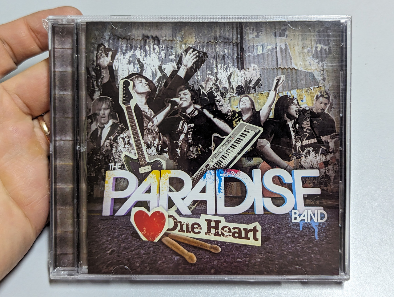 https://cdn10.bigcommerce.com/s-62bdpkt7pb/products/0/images/303181/The_Paradise_Band_One_Heart_Paradise_Entertainment_Audio_CD_1__95602.1696959651.1280.1280.jpg?c=2&_gl=1*9uk5ia*_ga*MjA2NTIxMjE2MC4xNTkwNTEyNTMy*_ga_WS2VZYPC6G*MTY5Njk1OTA2Mi4xMDk2LjEuMTY5Njk1OTY0OS42MC4wLjA.