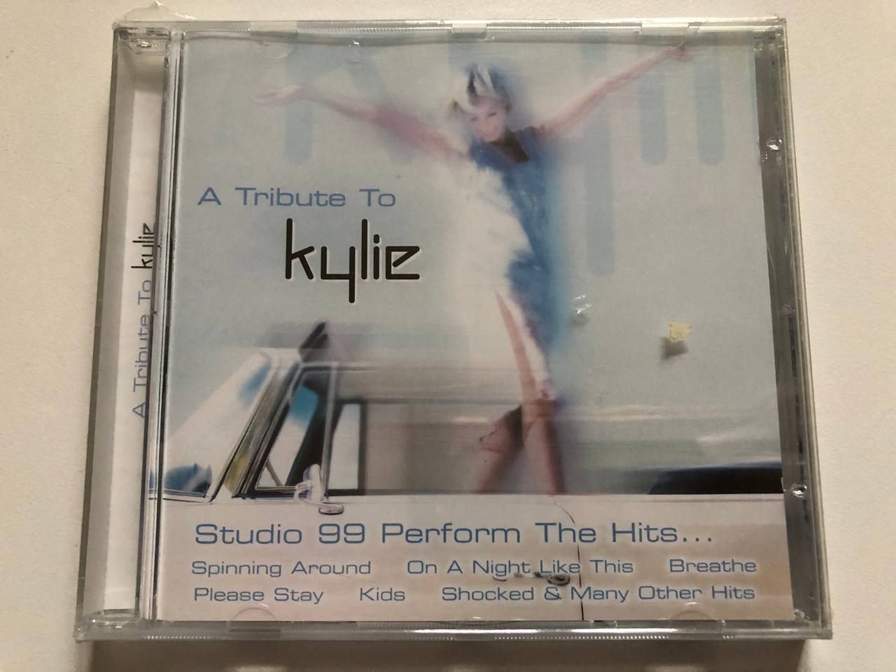 https://cdn10.bigcommerce.com/s-62bdpkt7pb/products/0/images/311404/A_Tribute_To_Kylie_Studio_99_Perform_The_Hits..._-_Spinning_Around_On_A_Night_Like_This_Breathe_Please_Stay_Kids_Shocked_Many_Others_Hits_Going_For_A_Song_Audio_CD_GFS494_1__19955.1699629877.1280.1280.JPG?c=2