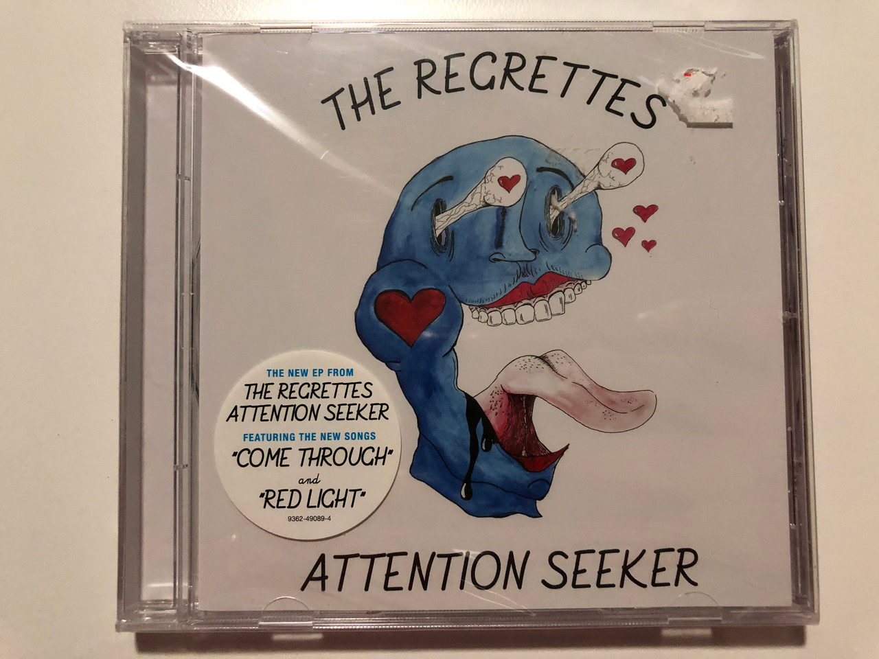 https://cdn10.bigcommerce.com/s-62bdpkt7pb/products/29789/images/177332/The_Regrettes_Attention_Seeker_The_New_EP_From_The_Recrettes_Attention_Seeker_Featuring_The_New_Songs_Come_Throuch_and_Red_Light_Warner_Bros._Records_Audio_CD_2018_9362-49089-4_1__94565.1620122497.1280.1280.JPG?c=2&_ga=2.124771082.1294282105.1620933183-96777119.1620933183