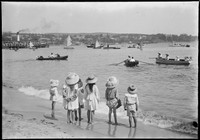 Six children standing on shoreline at Manly Cove.