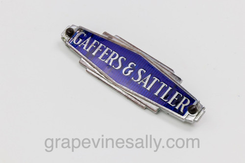 Original Vintage Gaffers & Sattler Stove Logo Emblem Badge. Attaching nuts/screws included.

MEASUREMENT:   Overall Length 3-1/2"   -   Rear Pegs 3-1/4"  
